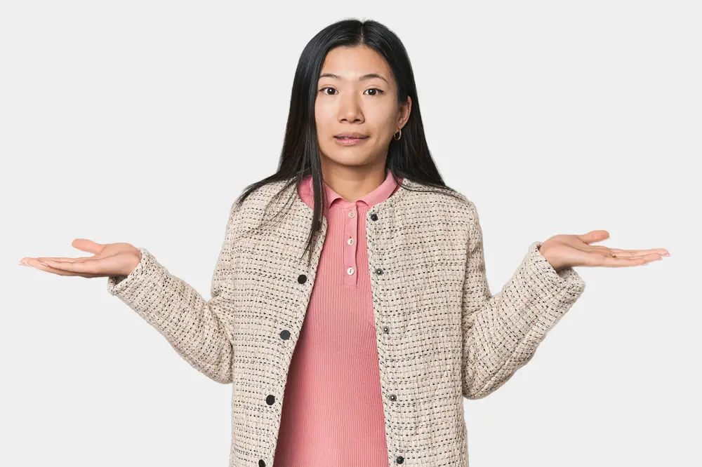 Young,Chinese,Woman,In,Studio,Setting,Confused,And,Doubtful,Shrugging