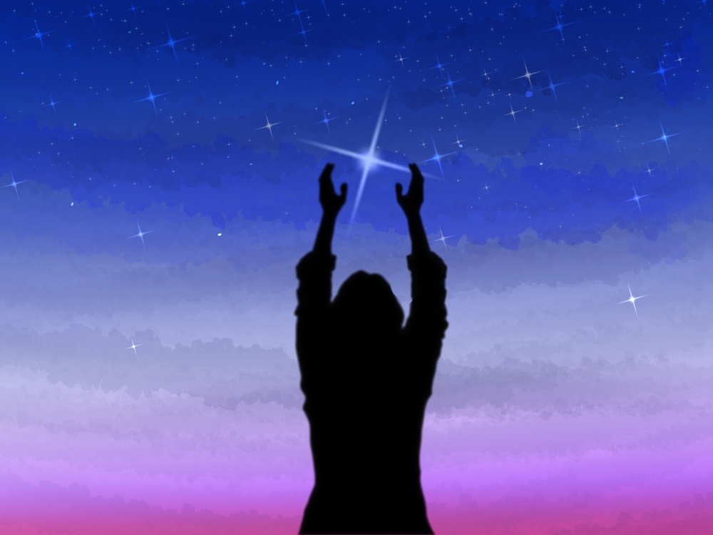 woman's silhouette reaching up to the brightest star.